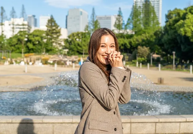 顔の前で手を握っている人の写真