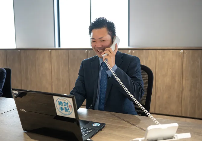 デスクで電話をしている人の写真